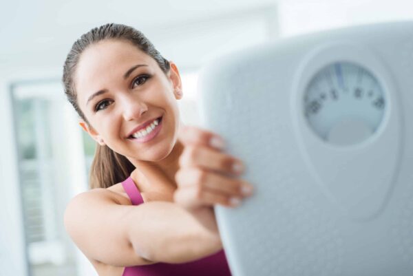 Weight Loss. Woman holding a scale.