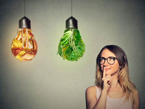 Organic Food. Woman choosing between healthy and unhealthy food options.