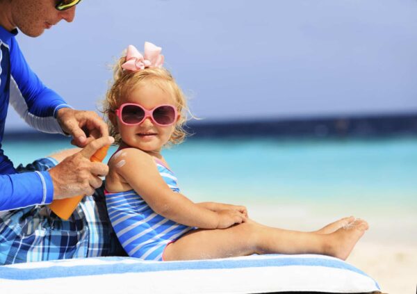 Sunscreen Protection. Dad applying sunscreen for his young daughter.