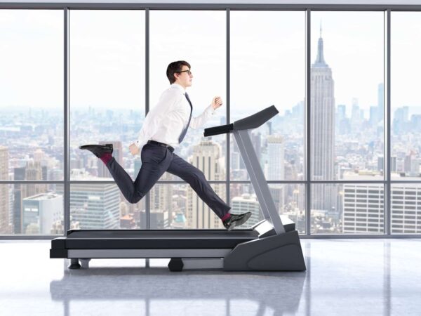 Exercise. Man on treadmill in office attire.